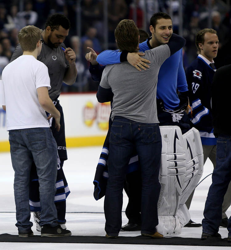 Trevor Hagan / Winnipeg Free Press
Dustin Byfuglien signs his jersey and Ondrej Pavelec gives a hug to a pair of lucky winners of the players jerseys after the Winnipeg Jets' final home game of the season versus the Montreal Canadiens on Thursday.
