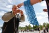 JESSICA BURTNICK / WINNIPEG FREE PRESS
A Winnipeg Blue Bomber fan gets a string of blue beads on the way in to Investors Group Field.