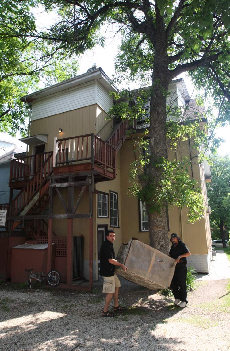 JOE BRYKSA / WINNIPEG FREE PRESS
Landlord Steve Tait (left) moves furniture from his Furby Street rooming house with a tenant.