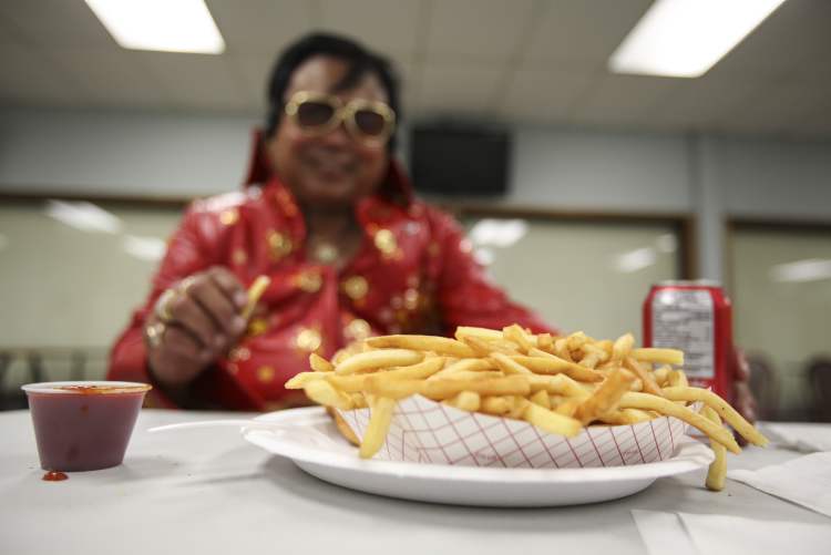 JESSICA BURTNICK / WINNIPEG FREE PRESS
One must eat like a king to sing like one. Jon Baunsit of Winnipeg calls himself the 'Filipino Elvis.' Here, he chows down on fries and a Coke — no peanut butter and banana sandwiches in sight.