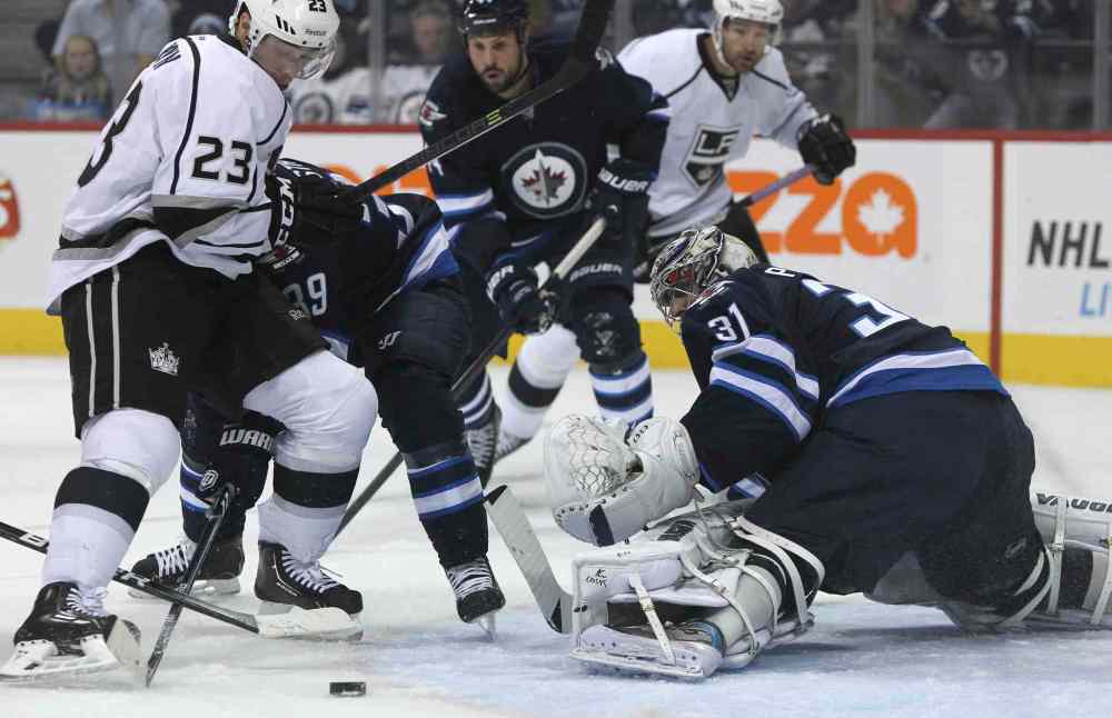 MIKE DEAL / WINNIPEG FREE PRESS
Winnipeg Jets goaltender Ondrej Pavelec (31) deflects the puck in the first period while Los Angeles Kings' Dustin Brown (23) tries to keep the puck in front of the net.