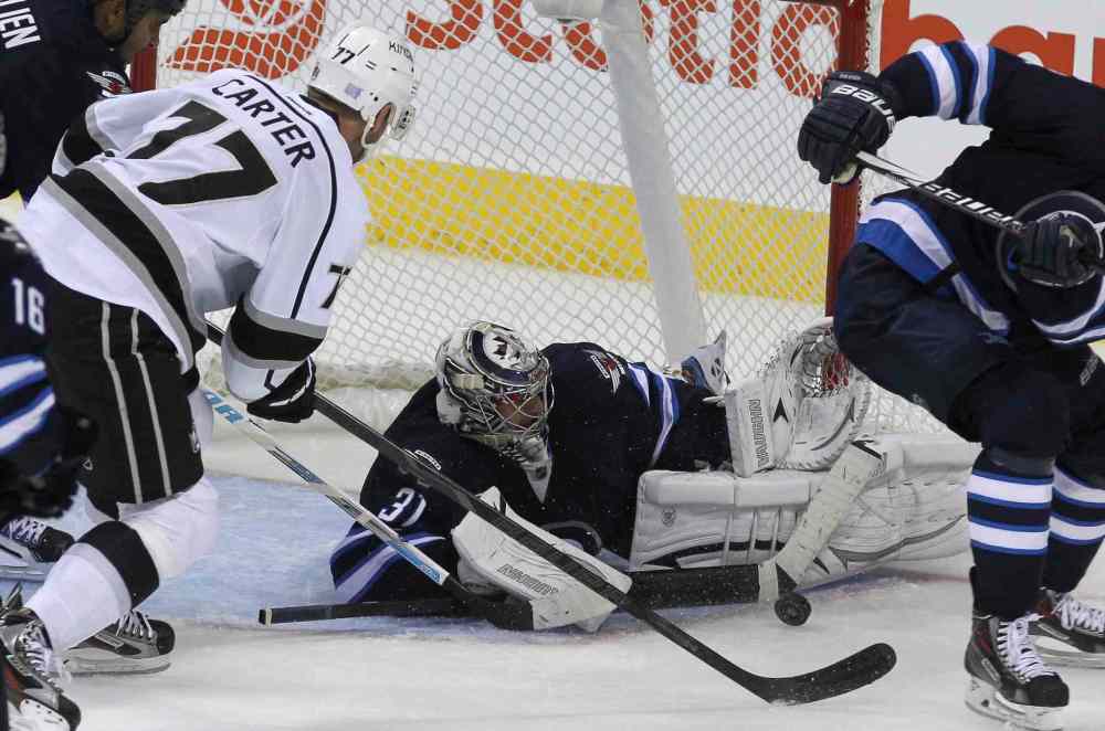 MIKE DEAL / WINNIPEG FREE PRESS
Winnipeg Jets' goaltender Ondrej Pavelec (31) makes a save while Los Angeles Kings' Jeff Carter (77) goes for a rebound in the third period.