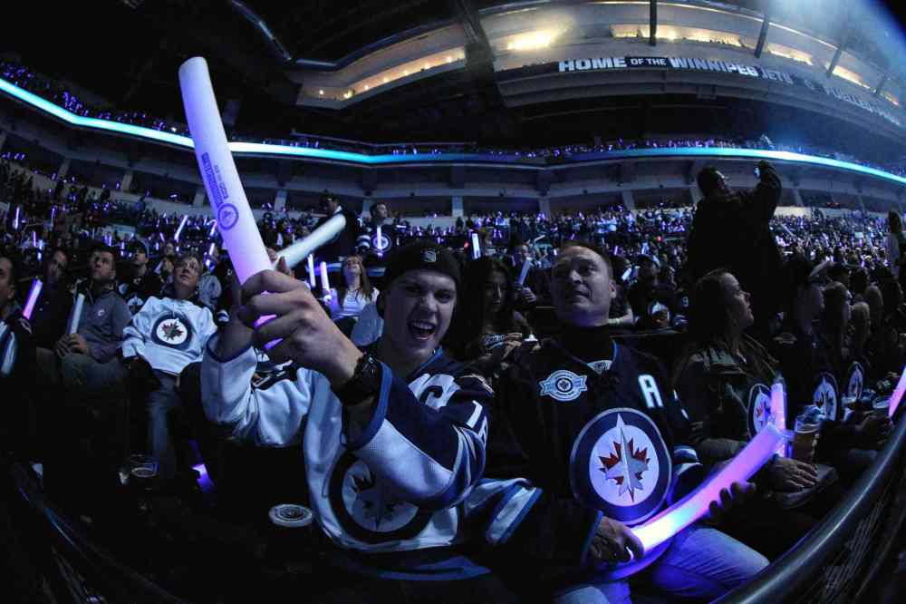 MIKE DEAL / WINNIPEG FREE PRESS
Brayden Carriere and his father Troy cheer as the Winnipeg Jets hit the ice.