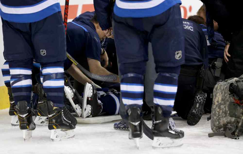 TREVOR HAGAN / WINNIPEG FREE PRESS
Winnipeg Jets' Jacob Trouba is attended to by medical personnel on the ice.