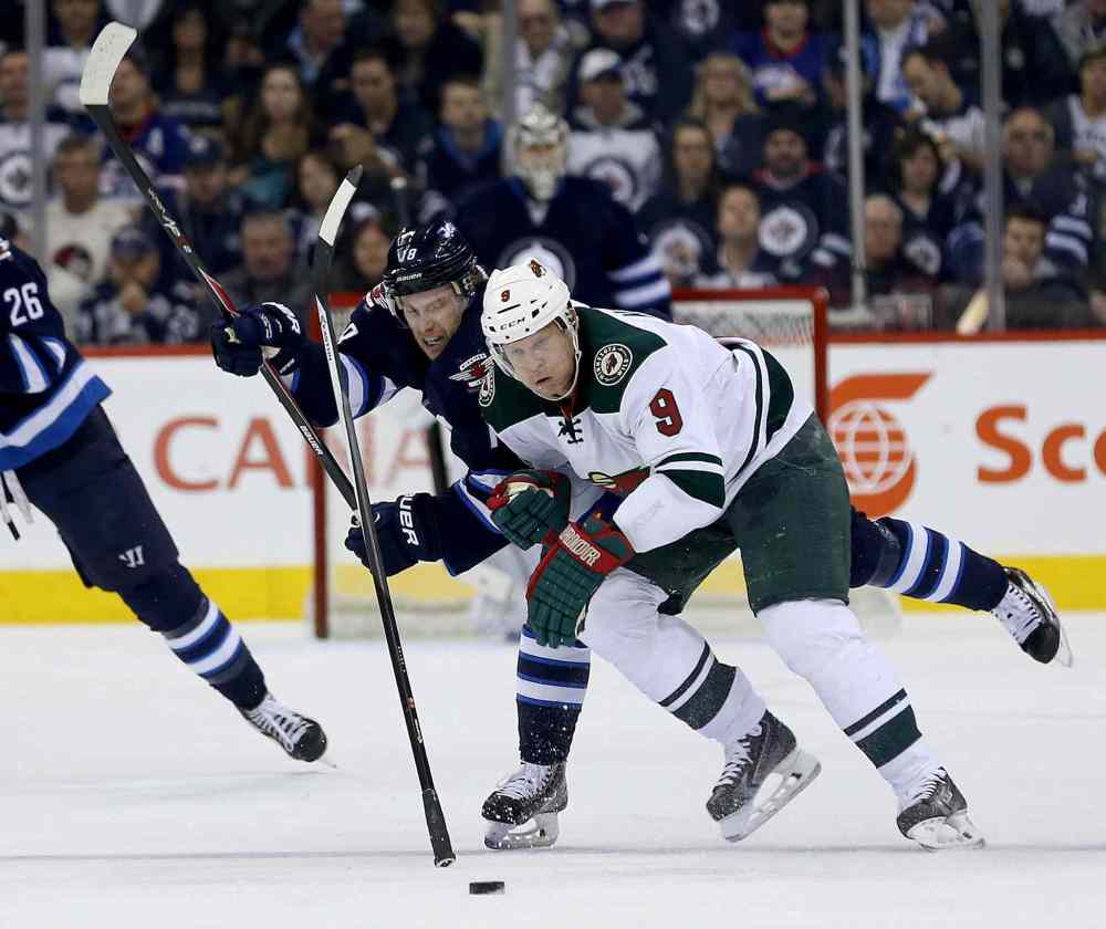 TREVOR HAGAN / WINNIPEG FREE PRESS
Winnipeg Jets forward Bryan Little and Minnesota Wild captain Mikko Koivu fight for the puck during the second period.