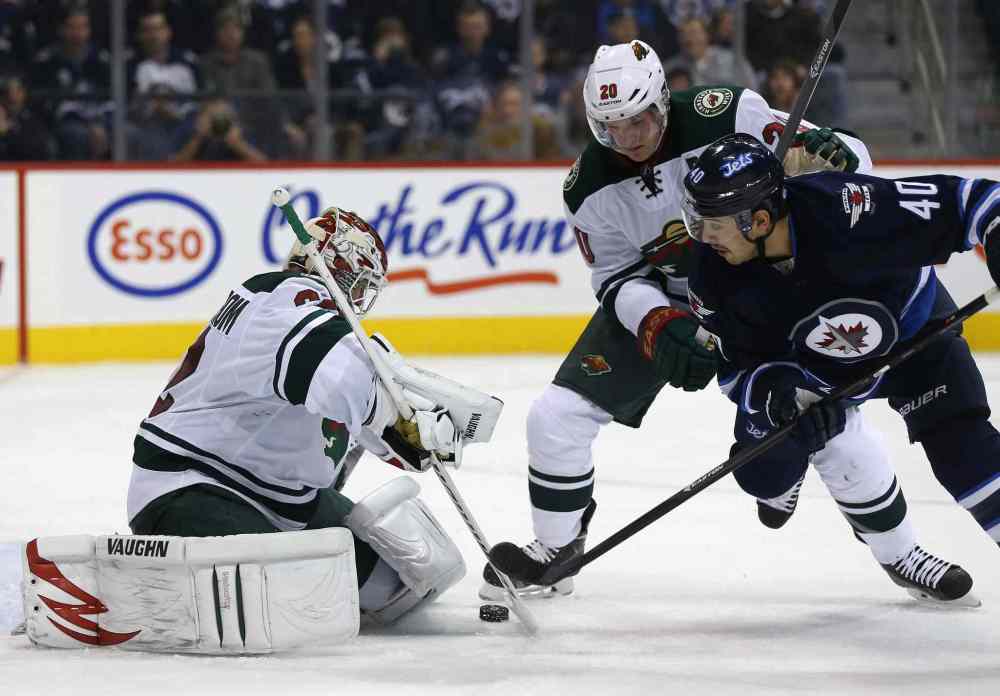 TREVOR HAGAN / WINNIPEG FREE PRESS
Minnesota Wild goaltender Niklas Backstrom stops a shot with Ryan Suter (centre) and Winnipeg Jets forward Devin Setoguchi battling in front of him during the second period.