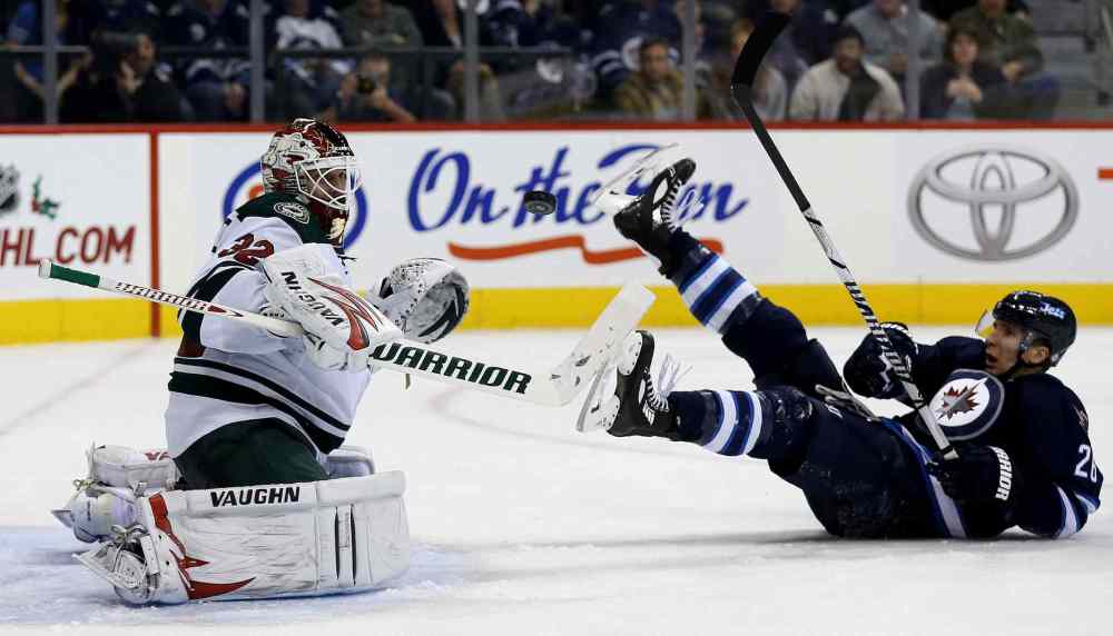 TREVOR HAGAN / WINNIPEG FREE PRESS
Minnesota Wild goaltender Niklas Backstrom watches a puck as Blake Wheeler slides on the ice during the second period.