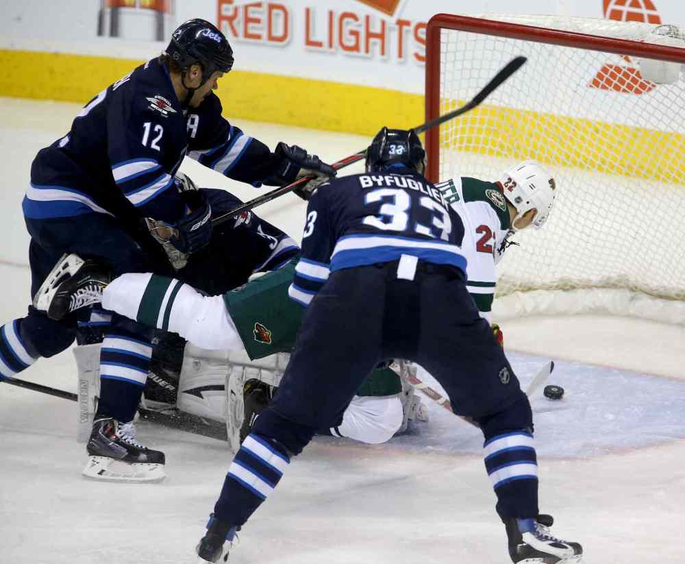 TREVOR HAGAN / WINNIPEG FREE PRESS
Minnesota Wild's Nino Niederreiter (right) gets through Winnipeg Jets skaters Olli Jokinen (left) and Dustin Byfuglien (centre) to beat goaltender Ondrej Pavelec during the third period.