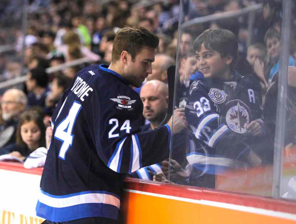 Boris Minkevich / Winnipeg Free Press
Winnipeg Jets defenceman Grant Clitsome signs a child's jersey. He doesn't seem upset that it's a Dustin Byfuglien jersey.