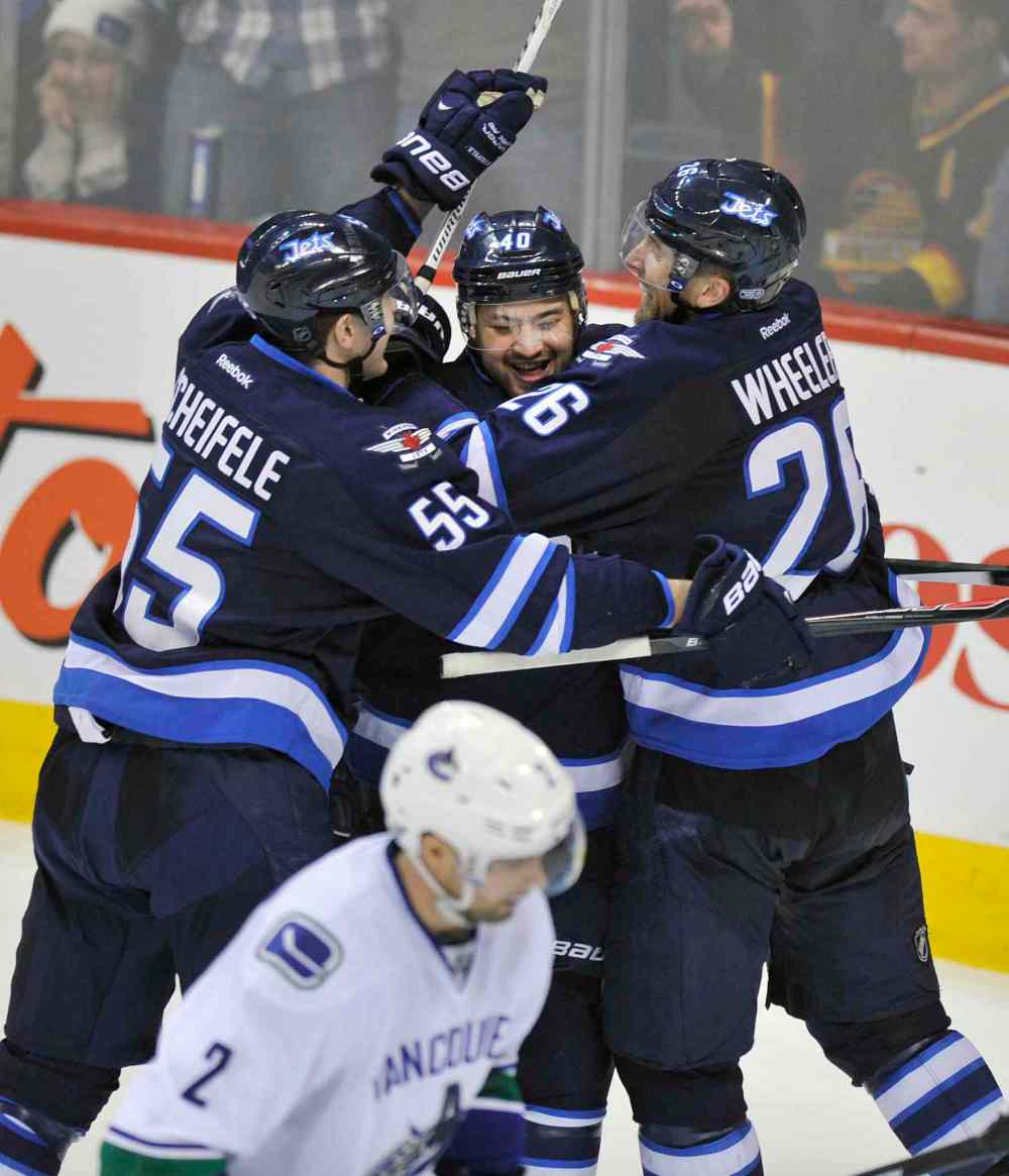 Fred Greenslade / Special to the WINNIPEG FREE PRESS
Winnipeg Jets' Devin Setoguchi is congratulated by teammates Mark Scheifele, left, and Blake Wheeler after scoring the game-winning goal against the Vancouver Canucks in Winnipeg Friday night. The Jets beat the Canucks 4-3.