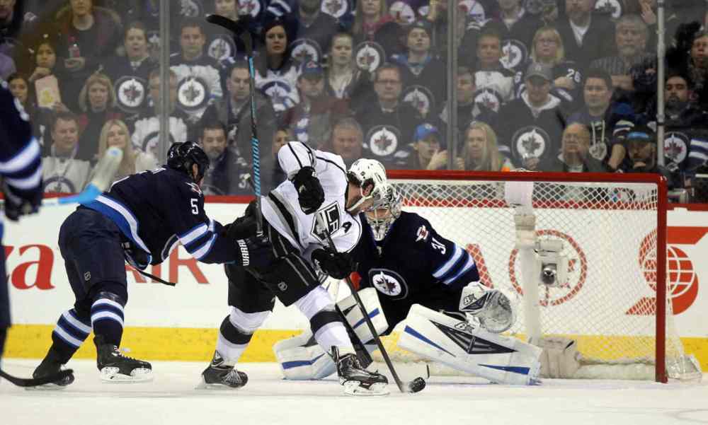 Phil Hossack / Winnipeg Free Press
An L.A. King moves in on Ondrej Pavelec behind Jets defenceman Mark Stuart in second period action.