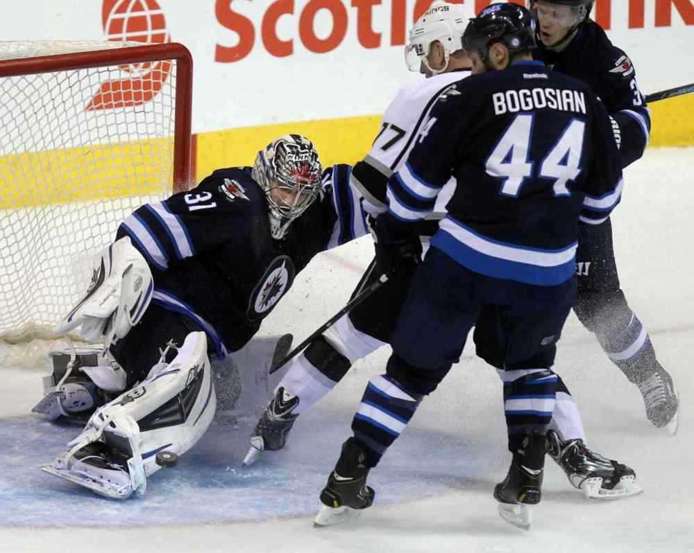 Phil Hossack / Winnipeg Free Press
Ondrej Pavelec covers up as Zach Bogosian, Tobias Engstrom and Los Angeles King Jeff Carter slide to a stop in the crease in the third period.