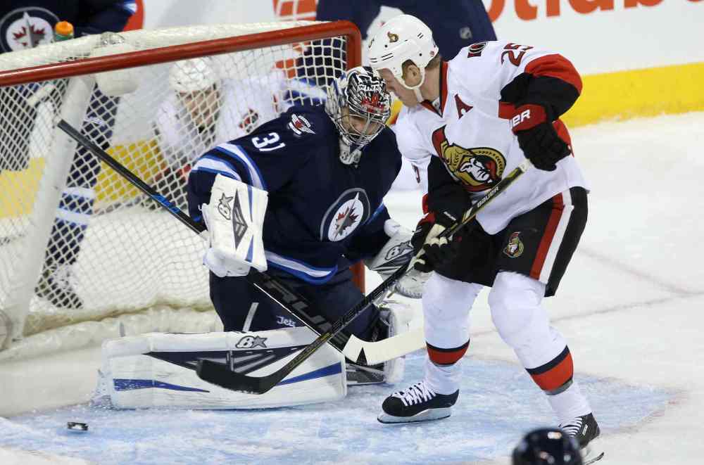 TREVOR HAGAN / WINNIPEG FREE PRESS
Winnipeg Jets' goaltender Ondrej Pavelec (31) and Ottawa Senators' Chris Neil (25) watch the puck slide through the crease during in Winnipeg Saturday.