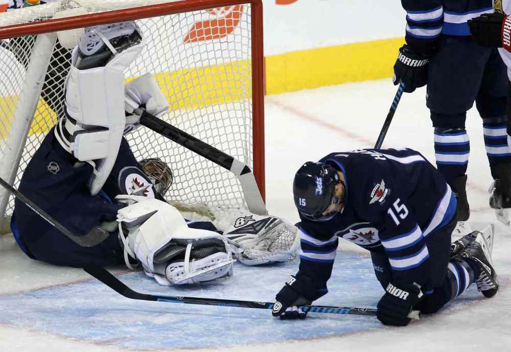 TREVOR HAGAN / WINNIPEG FREE PRESS
Winnipeg Jets' goaltender Ondrej Pavelec (31) lies in the net after a puck took a strange bounce off of Matt Halischuk (15). The goal was credited to Ottawa Senators' Milan Michalek (9), not shown, during first period NHL hockey action at MTS Centre in Winnipeg Saturday.