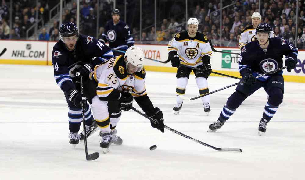 Phil Hossack / Winnipeg Free Press
Jets' Anthony Peluso and Bruins' Matt Bartkowski trip each other up as they follow the puck over the Boston blue line during the second period of Thursday's game.
