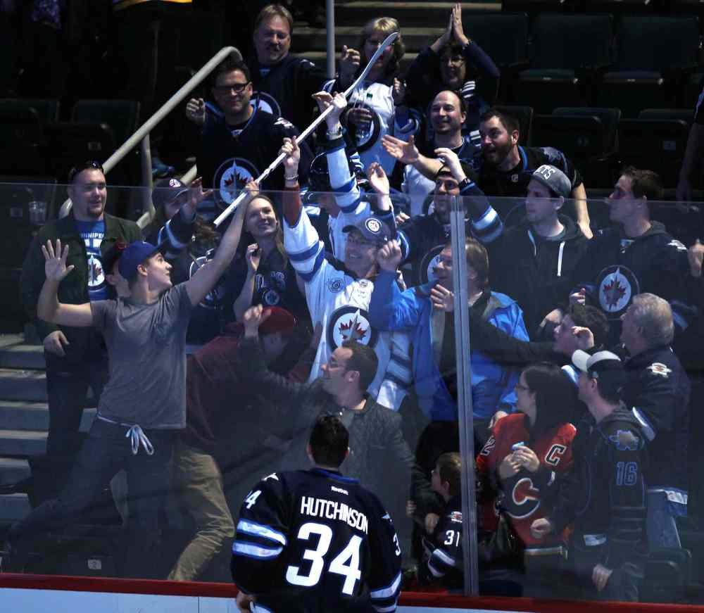 Phil Hossack / Winnipeg Free Press
Fans scramble for Winnipeg Jets' goalie Michael Hutchinson's game stick after he was awarded the first star of the game after a 2-1 shootout victory over the Boston Bruins at the MTS Centre Thursday.