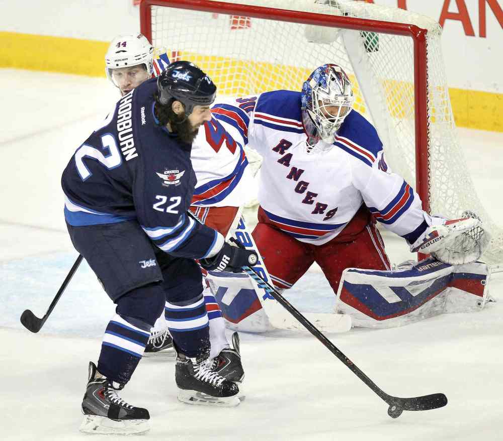 Phil Hossack / Winnipeg Free Press
Winnipeg Jets Chris Thorburn handles the puck in front of New York Rangers goalie Henrik Lundqvist as Rangers Matt Hunwick watches.