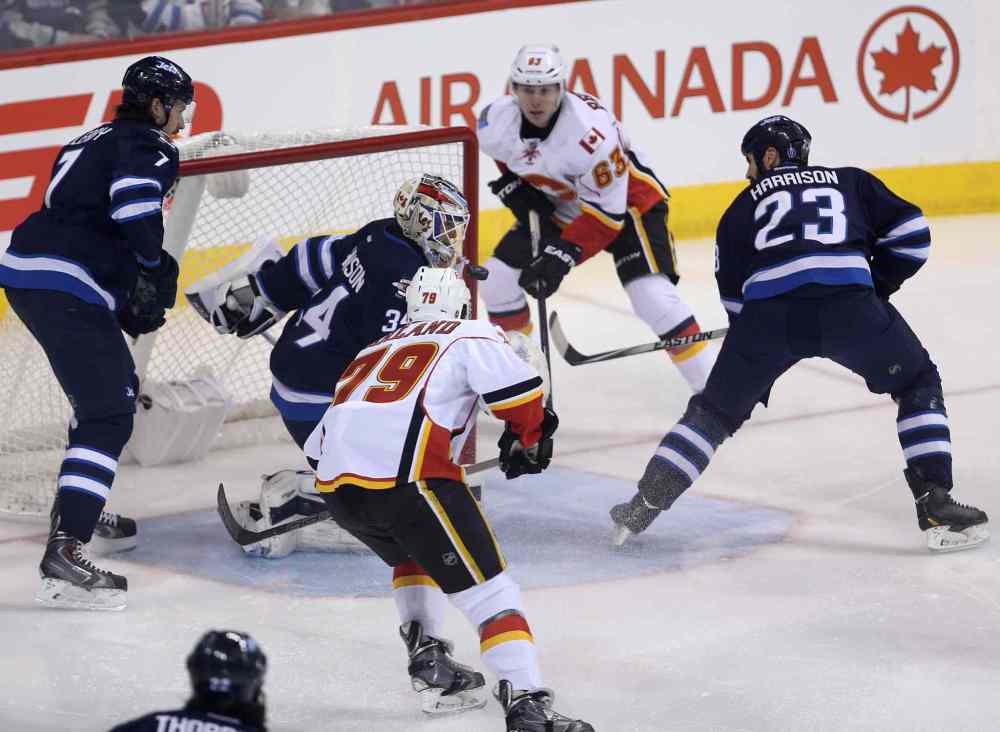 TREVOR HAGAN/WINNIPEG FREE PRESS
Calgary Flames' Sam Bennett (63) at the side of the net and Michael Ferland (79) right before Ferland opened the scoring on Winnipeg Jets' goaltender Michael Hutchinson (34) in the first minute of NHL hockey action on Saturday.