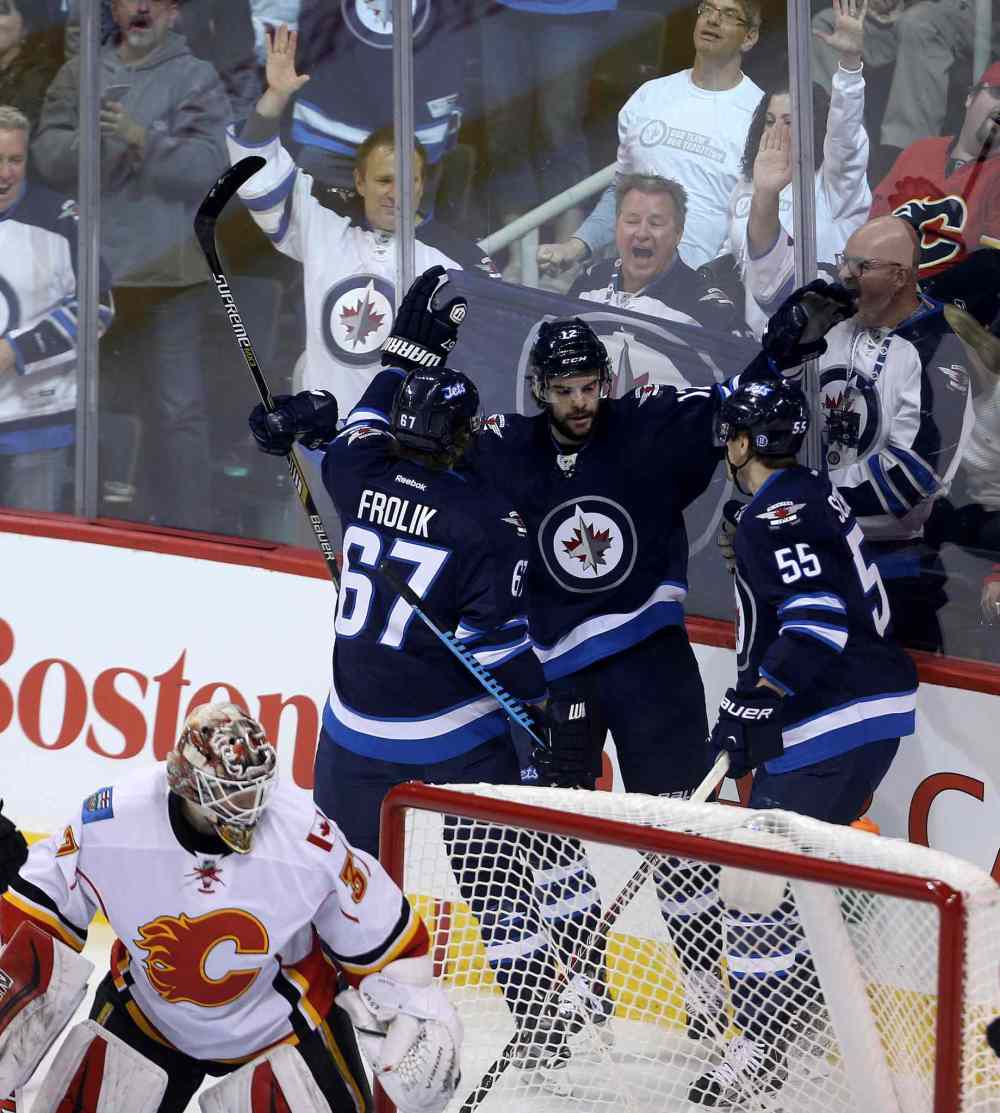 TREVOR HAGAN/WINNIPEG FREE PRESS
Winnipeg Jets' Michael Frolik (67), Drew Stafford (12) and Mark Scheifele (55) celebrate after Stafford scored on Calgary Flames' Joni Ortio (37) during NHL hockey action on Saturday.