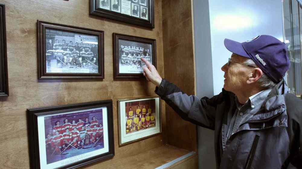 JOE BRYKSA / WINNIPEG FREE PRESS Walter Mueller looks at team pictures from back when he played inside the Manitou Community Arena.