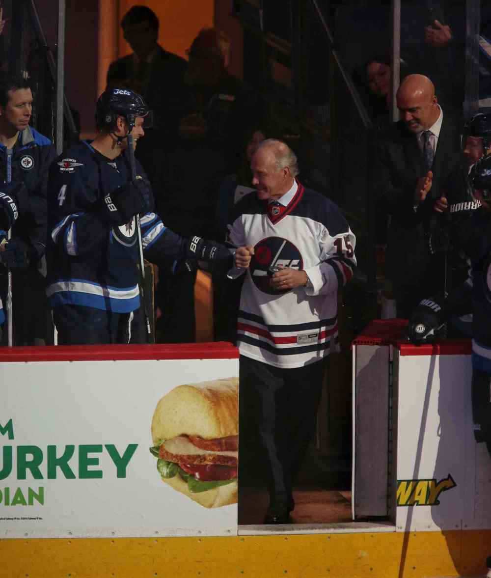 MIKE DEAL / WINNIPEG FREE PRESS
Anders Hedberg fist bumps Paul Postma on his way to centre ice. Hedberg, Bobby Hull (who was not present for the induction) and Ulf Nilsson, played together for the Jets from 1974-78. The trio — known as the Hot Line — were inducted into the Winnipeg Jets Hall of Fame prior to the start of the game between the Jets and the Toronto Maple Leafs at the MTS Centre Wednesday evening.