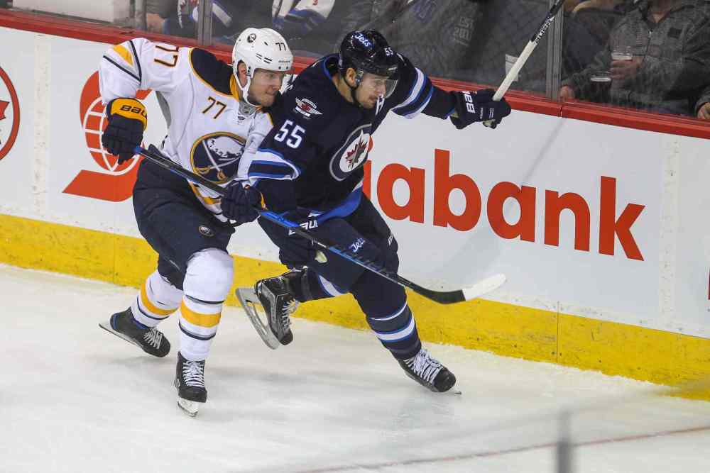 MIKE DEAL / WINNIPEG FREE PRESS
Winnipeg Jets' Mark Scheifele (55) goes for the puck while Buffalo Sabres' defenceman Dmitry Kulikov (#77) tries to slow him down.