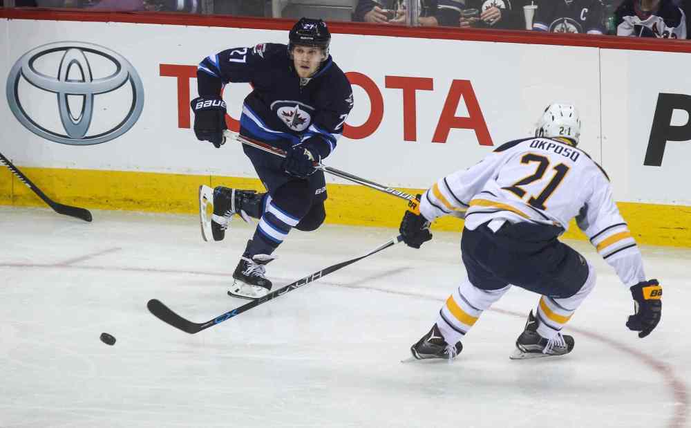 MIKE DEAL / WINNIPEG FREE PRESS
Winnipeg Jets' Nikolaj Ehlers (27) passes the puck past Buffalo Sabres' forward Kyle Okposo (#21).
