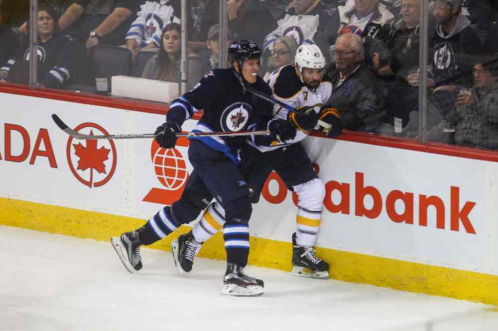 MIKE DEAL / WINNIPEG FREE PRESS
Winnipeg Jets' Patrik Laine (29) forces Buffalo Sabres' defenceman Zach Bogosian (#47) against the boards.