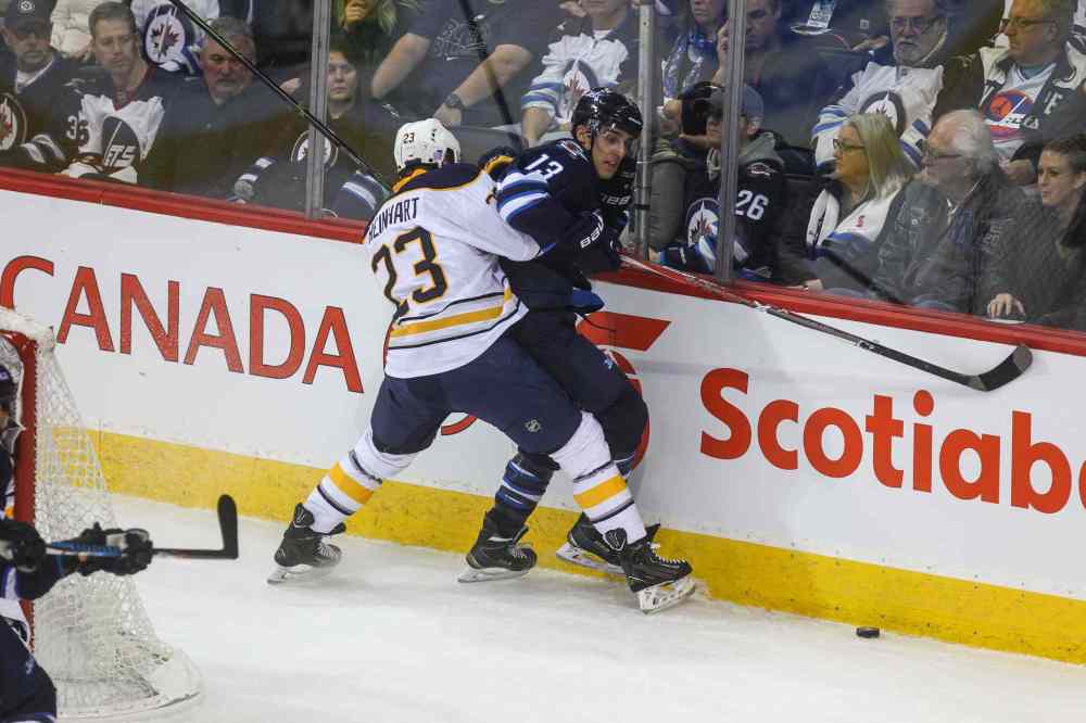 MIKE DEAL / WINNIPEG FREE PRESS
Winnipeg Jets' Brandon Tanev (13) is checked against the boards by Buffalo Sabres' forward Sam Reinhart (#23).