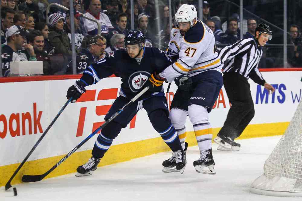 MIKE DEAL / WINNIPEG FREE PRESS
Winnipeg Jets' Alexander Burmistrov (91) tries to keep the puck while being checked by Buffalo Sabres' defenceman Zach Bogosian.
