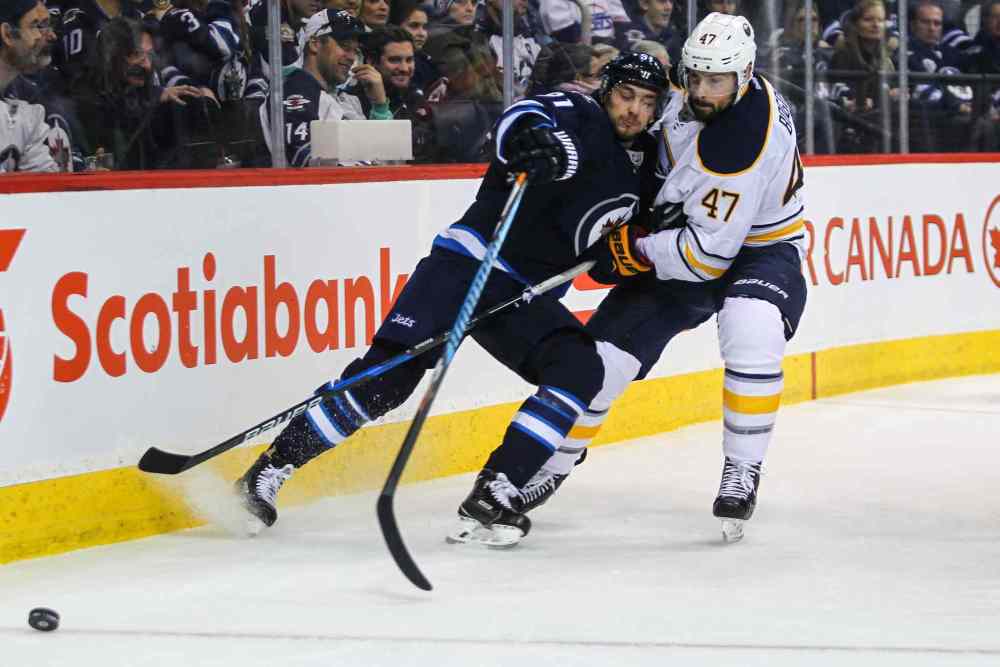 MIKE DEAL / WINNIPEG FREE PRESS
Winnipeg Jets' Alexander Burmistrov (91) tries to keep the puck while being checked by Buffalo Sabres' defenceman Zach Bogosian.