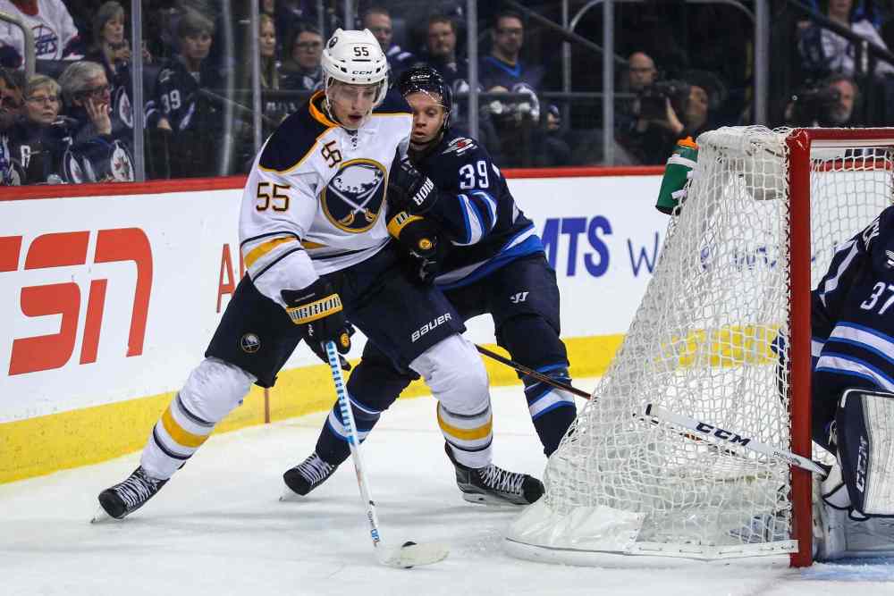 MIKE DEAL / WINNIPEG FREE PRESS
Winnipeg Jets' Toby Enstrom (39) tries to knock Buffalo Sabres' defenceman Rasmus Ristolainen (#55) off the puck.