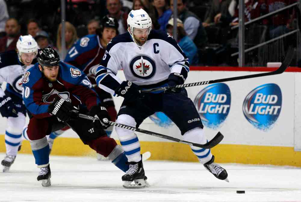 David Zalubowski / The Associated Press
Andrew Ladd (right) is hooked by Colorado Avalanche centre Ryan O'Reilly while reaching for the puck in the first period.