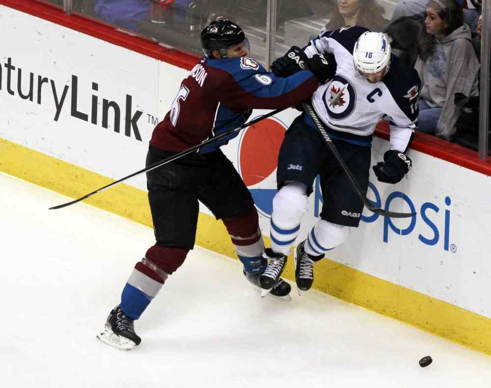 David Zalubowski / The Associated Press
Colorado Avalanche defenseman Erik Johnson (left) sends Jets captain Andrew Ladd into the boards in the third period.