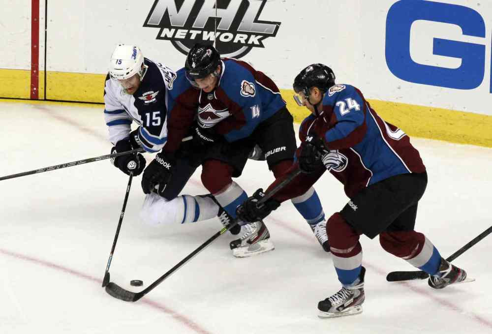 David Zalubowski / The Associated Press
Jets winger Matt Halischuk (left) battles for control of the puck with Colorado Avalanche defenceman Tyson Barrie (centre) and center Marc-Andre Cliche in the third period.
