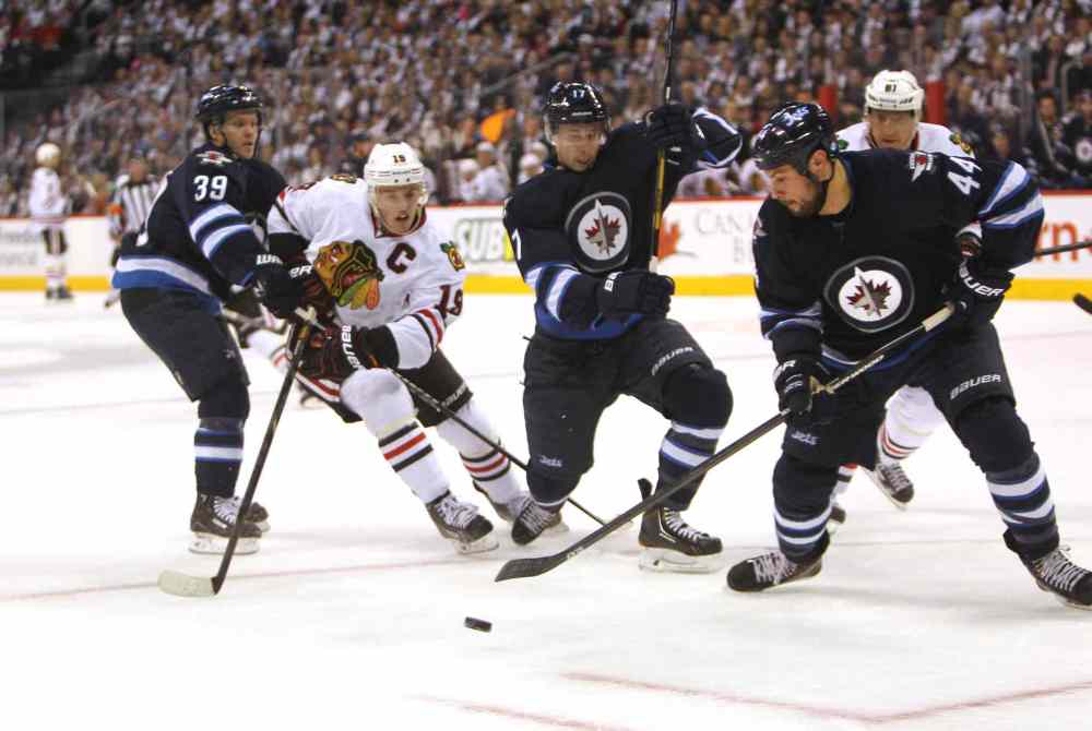 Zach Bogosian (second from right) tries to get the puck out of the Jets zone during the first period as (from left) Toby Enstrom, Jonathan Toews, James Wright and Marion Hossa scramble for the puck.