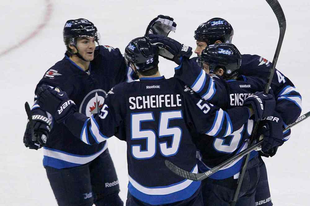 John Woods / The Canadian Press
Members of the Winnipeg Jets celebrate a first-period goal by Toby Enstrom (bottom right). The goal would be the Jets' lone marker Saturday afternoon.