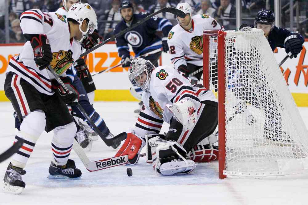 John Woods / The Canadian Press
Chicago Blackhawks goaltender Corey Crawford (50) makes a save off a Matt Halishchuk shot as Johnny Oduya (left) picks up the rebound during the second period.