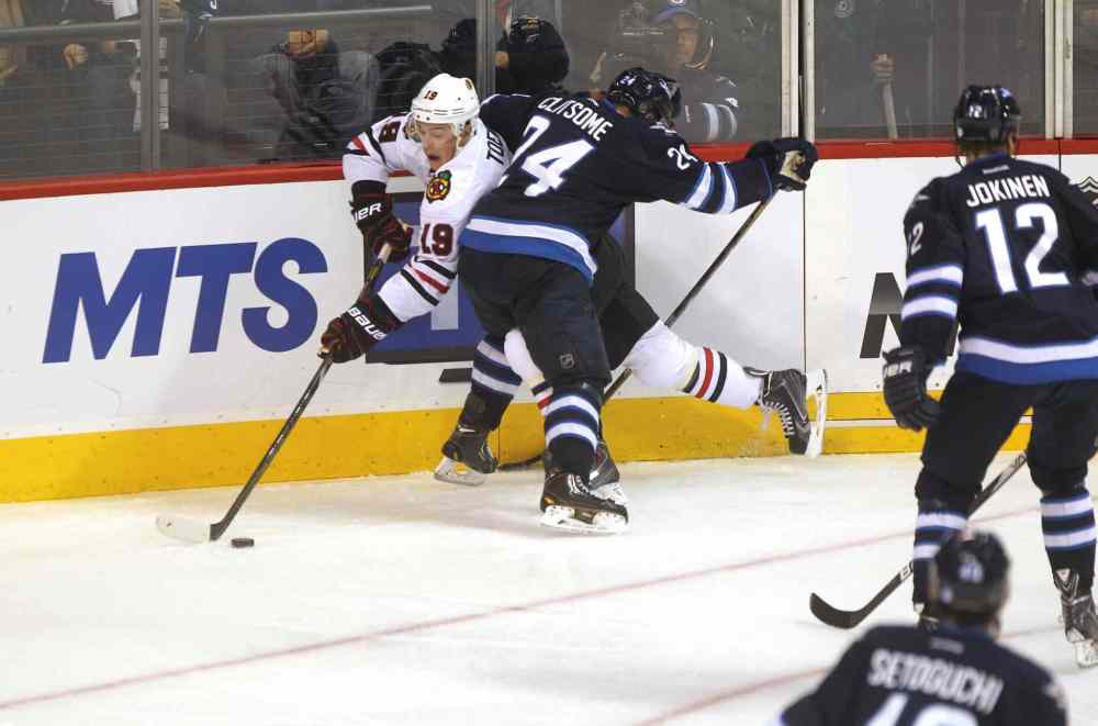 Ruth Bonneville / Winnipeg Free Press
Grant Clitsome (24) checks Jonathan Toews (left) as Olli Jokinen (12) looks on during the third period.