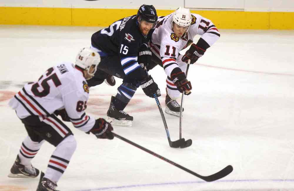 Ruth Bonneville / Winnipeg Free Press
Matt Halischuk (centre) tries to get the puck from Jeremy Morin (right) during the third period.