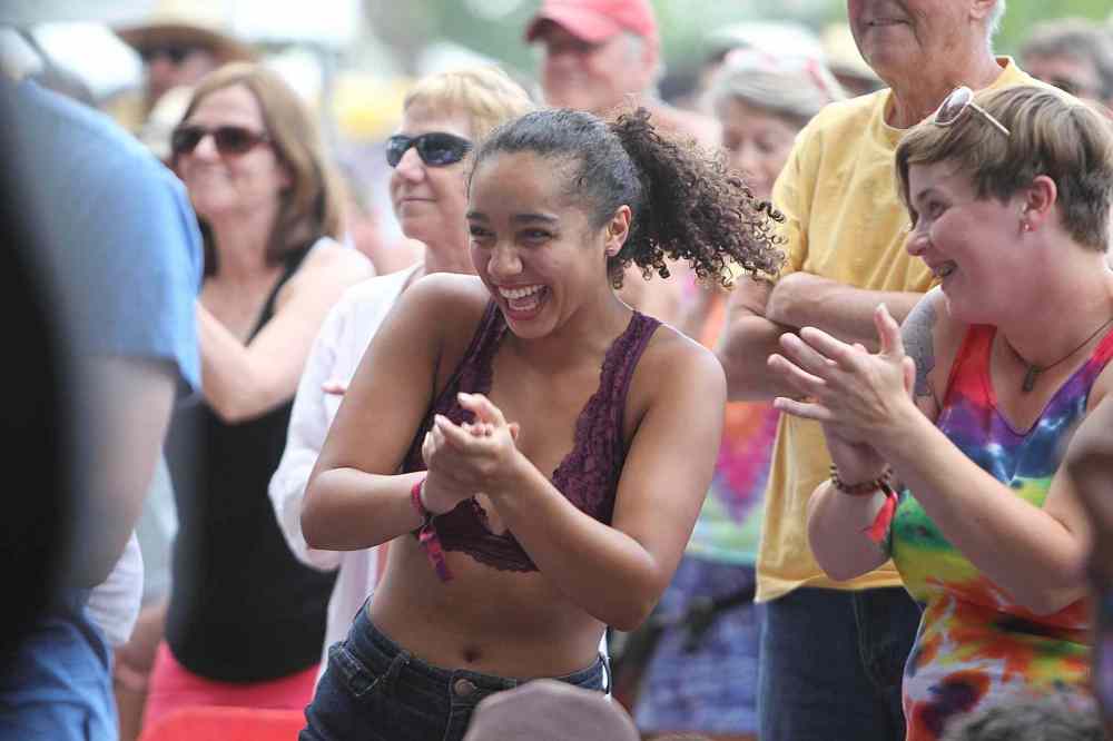 RUTH BONNEVILLE / WINNIPEG FREE PRESS
Kari Johnson (curly hair, centre) dances and claps with the band on stage with her friend Amanda Murphy (rainbow shirt) beside her at the 44th annual Folk Festival at Birds Hill Park Saturday.