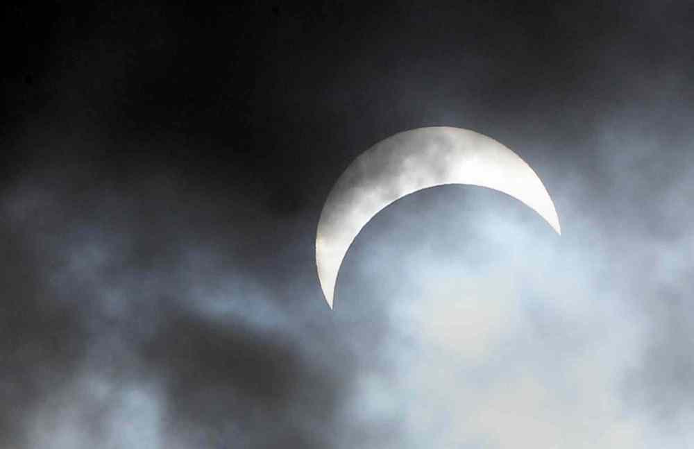 JOE BRYKSA / WINNIPEG FREE PRESS
The moon covers about 70 percent of the sun at 1 p.m. during a partial eclipse for a few quick seconds as clouds broke over Winnipeg.