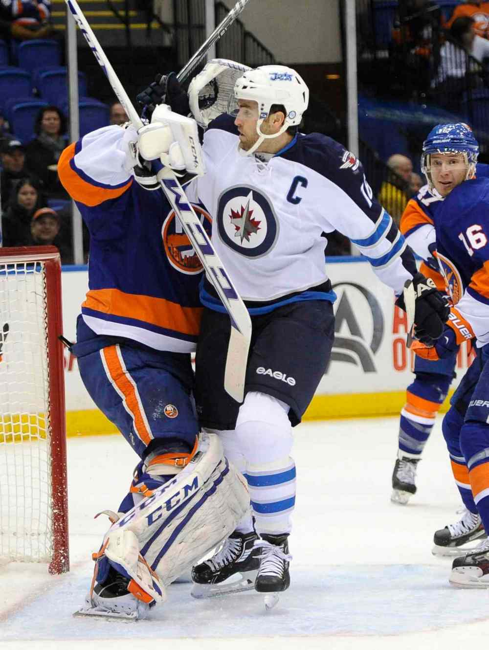 Kathy Kmonicek / The Associated Press
New York Islanders goalie Kevin Poulin (left) battles with Winnipeg Jets forward Andrew Ladd in front of the net in the first period.