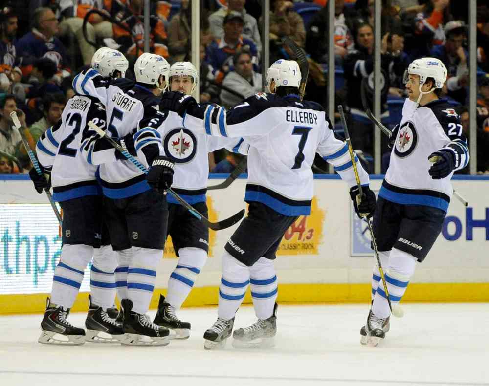 Kathy Kmonicek / The Associated Press
Winnipeg Jets' Mark Stuart (second from left) celebrates his goal with teammates in the second period.