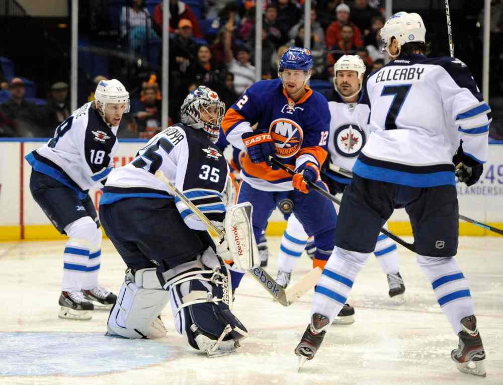 Kath Kmonicek / The Associated Press
Winnipeg Jets goalie Al Montoya (35) keeps his eyes on an airborne puck as he defends against New York Islanders winger Josh Bailey (centre) in the second period as Bryan Little (left), Mark Stuart (centre right) and Keaton Ellerby close in.
