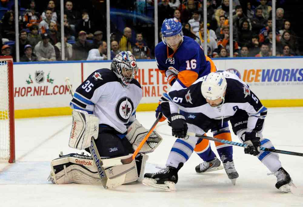 Kath Kmonicek / The Associated Press
New York Islanders' Peter Regin (centre) and Winnipeg Jets defenceman Mark Stuart (right) scuffle in front of the net as Jets goalie Al Montoya defends during the second period.