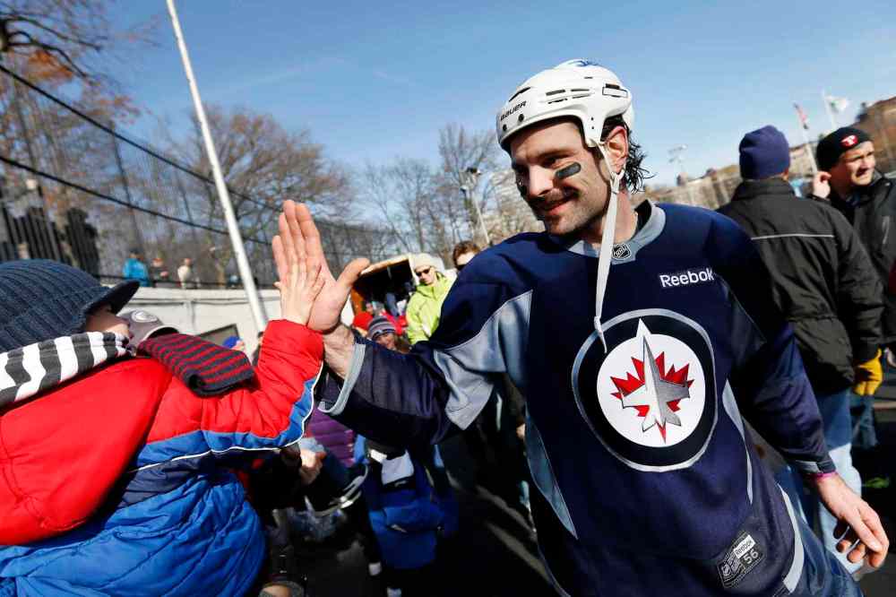 Jason DeCrow / The Associated Press
Winnipeg Jets defenceman Mark Stuart high-fives four-year-old fan James MacDonald after practice.