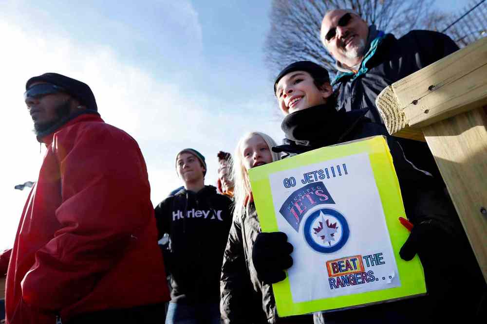 Jason DeCrow / The Associated Press
New York Islanders fan Alexander Neuhaus, 10, of New York, holds up a sign wishing the Winnipeg Jets luck in their game against the New York Rangers on Monday.