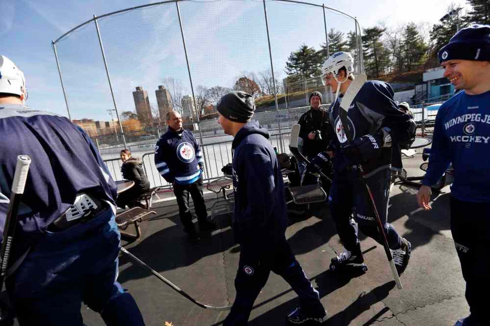 Jason DeCrow / The Associated Press
Fans look on as members of the Winnipeg Jets take to the ice.