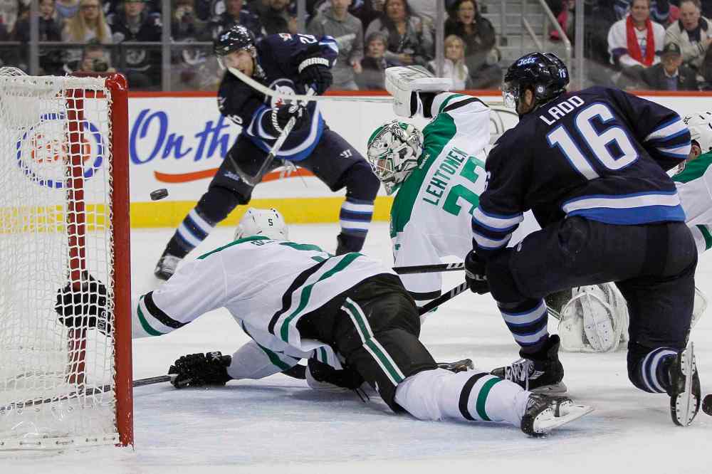 JOHN WOODS / THE CANADIAN PRESS
Blake Wheeler (top) puts the puck past Jamie Oleksiak (bottom) and goaltender Kari Lehtonen (centre right) as Andrew Ladd looks on during the second period.